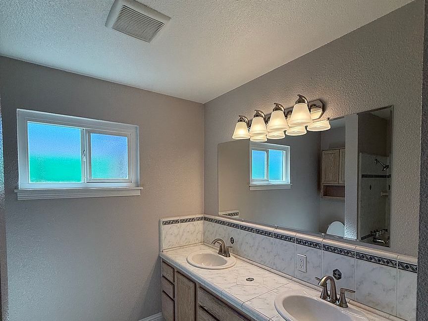 1203 Woodworth Ave, Yuba City — remodeled bathroom with double vanity by Yuba Sutter Real Estate Group