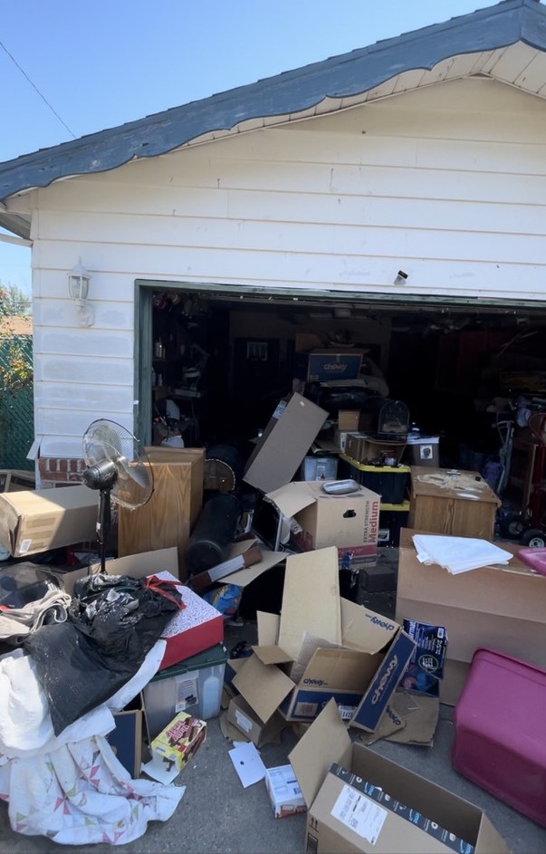 Belongings filling the garage and spilling into the driveway at the Woodworth Avenue house on the day of purchase